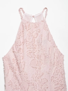 Detail view of blush pink halter neck dress featuring textured fringe and back button closure