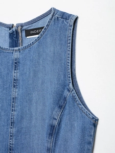 Detail of blue denim dress neckline with double stitching and black woven brand label