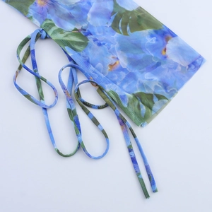 Detail of sheer mesh dress with blue floral print and adjustable drawstring closure