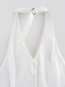 Detail of white halter vest with V-neckline, twill fabric texture, and metal D-ring buckle