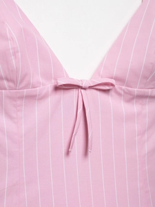 Close-up of pink and white striped dress featuring a V-neckline and a cute bow detail