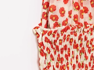 Detailed view of invisible zipper and elastic smocking on red floral summer dress