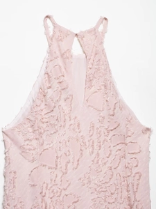 Close-up of pink halter top featuring unique fringe texture and back teardrop button closure