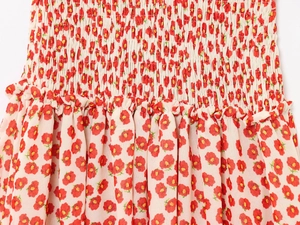 Detail of red floral chiffon mini dress showing smocked bodice and ruffled texture
