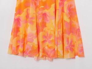 Detailed view of vibrant orange and pink floral prints on lightweight summer dress hem
