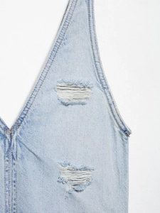 Detailansicht eines Jeanskleides in Hellblau mit Destroyed-Effekten und Kontrastnähten
