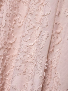 Macro view of pink fringe jacquard fabric with feather-like texture on the dress