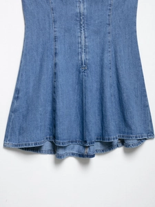 Detail of A-line denim skirt stitching and washed blue fabric paneling on sleeveless dress