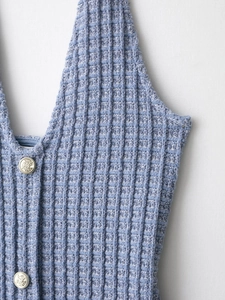 Gros plan sur la texture en tweed bleu clair et les boutons argentés de la veste d'été