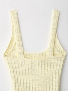 Macro detail of the pale yellow knitted fabric texture and ribbed pattern on the dress