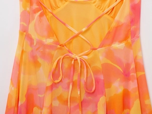 Detailed back view of orange and pink tie-dye mesh dress featuring lace-up crisscross straps