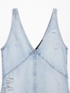 Detailansicht eines Jeanskleides in Hellblau mit V-Ausschnitt und Destroyed-Effekt