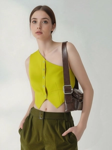 Dettaglio del gilet asimmetrico verde lime monospalla con fondo a V e bottoni anteriori