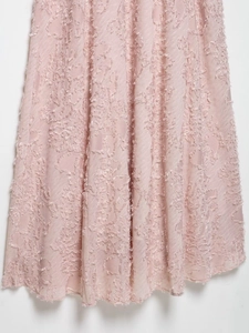 Detail of light pink floral jacquard fabric with delicate textured tassel embroidery