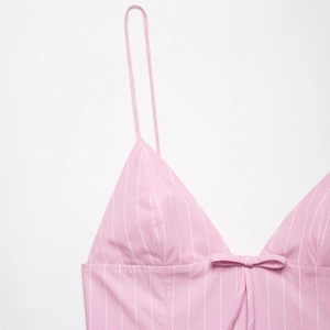 Pink and white vertical striped sundress with fine spaghetti straps and front bow detail