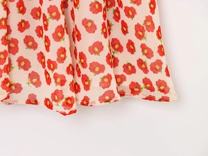 Detail of light pink floral summer dress showing hemline stitching and chiffon fabric