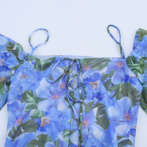 Detailed close-up of blue floral print mesh fabric with delicate lace-up neckline straps