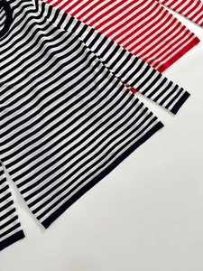 Detailed flat lay of striped knit sweaters in black-white and red-white colorways
