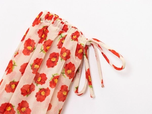 Detail of floral chiffon fabric with elastic pleated cuff and decorative drawstring ties