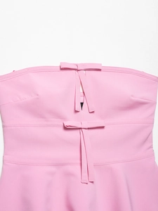 Close-up of pink strapless top featuring double bow decoration and teardrop cutout detail