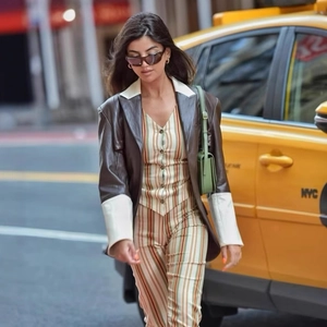 Completo chic da donna con gilet a righe arcobaleno e pantaloni su una strada di NYC