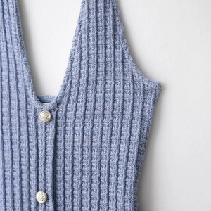 Gilet bleu foncé à col en V en maille gaufrée avec boutons tête de lion dorés