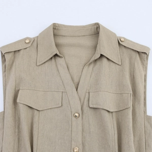 Close-up of khaki pleated dress with military epaulettes and gold buttons on shoulders