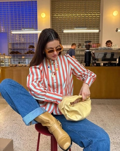 Detail of red and white striped puff sleeve shirt styled with a yellow cloud clutch bag