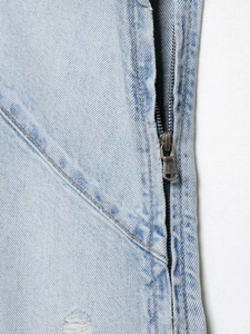 Detail von Metallreißverschluss und orangefarbenen Nähten auf hellblauem Jeanskleid