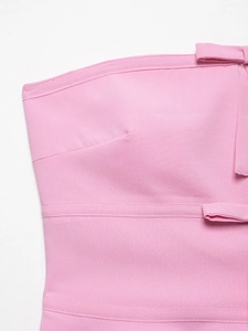Detailed close-up of pink strapless top showing fine stitching and bow ornament