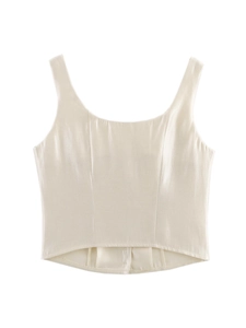 Detail of champagne satin corset top with U-neckline and curved hemline on white background
