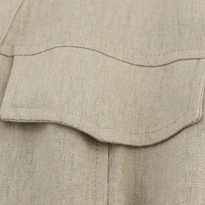 Detail shot of khaki linen fabric texture and precise stitching on the pocket flap