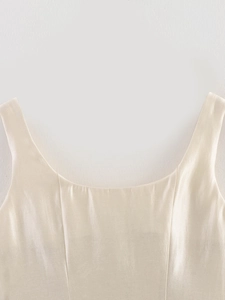 Close-up of champagne satin top neckline showing smooth silk texture and fine stitching