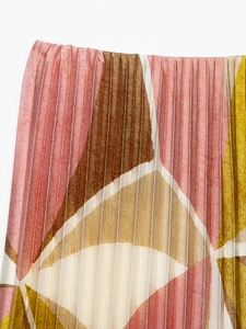 Macro detail of geometric print pleated fabric with fine vertical textures and elegant tones