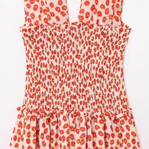 Floral backless mini dress with red flower print, smocked bodice and ruffled hemline