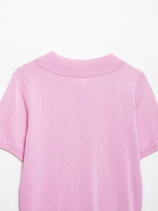 Détail du haut en maille rose montrant la texture fine et le col rond élégant