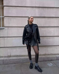 Street style view of a black leather biker jacket with silver metal zipper details