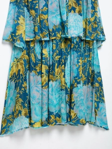 Close-up of vibrant floral print fabric and tiered ruffle layers with frayed edge details