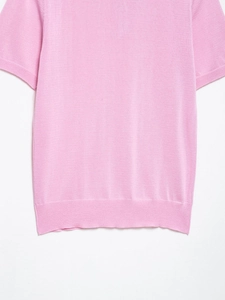 Vue détaillée du tissu en maille rose et de l'ourlet côtelé de ce haut décontracté court