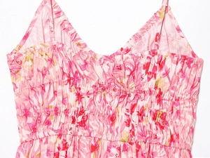 Detail of pink floral dress featuring smocked chest design and adjustable spaghetti straps