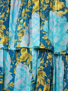Detailed macro view of bohemian floral print fabric with layered ruffle hem decoration
