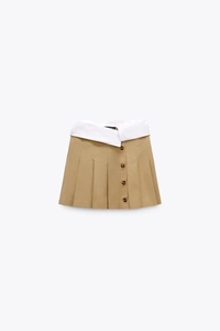 Vue détaillée de la jupe-short plissée kaki avec taille contrastée blanche et boutons bruns