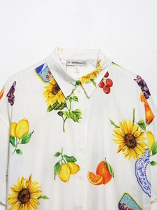 Détail de l'imprimé floral et fruitier sur chemise en coton blanc avec étiquette de col