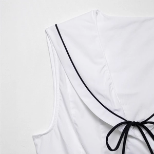 White sleeveless top with navy sailor collar and black bow tie decoration