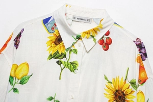 Gros plan détaillé des imprimés de fleurs et fruits sur tissu de chemise en coton blanc