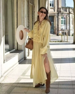 Dettaglio vestito in chiffon giallo chiaro con scollo a V a balze e elegante fiocco