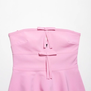 Pink strapless top featuring double bow accents and stylish cutout details in 2025 summer style