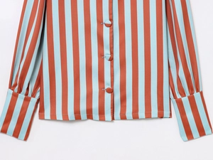 Detail view of striped shirt featuring orange and blue stripes with fabric-covered buttons