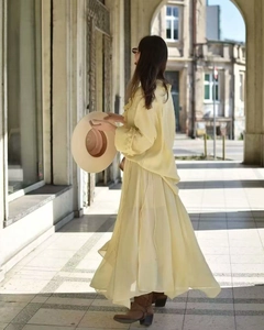 Dettaglio dell'abito in chiffon giallo chiaro con maniche lunghe e gonna fluida stile francese