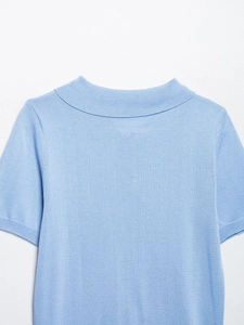 Détail de la texture en maille fine et de l'encolure ronde sur ce haut bleu clair